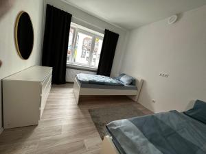 ein Schlafzimmer mit einem Bett, einer Kommode und einem Fenster in der Unterkunft Wohnung am Marktplatz in Gießen