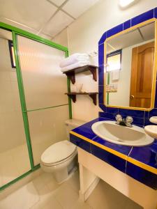 a bathroom with a toilet and a sink and a mirror at Ecohotel La Casona in Pereira