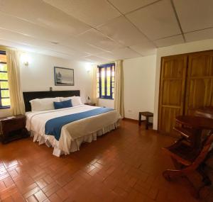 1 dormitorio con 1 cama grande y suelo de madera en Ecohotel La Casona, en Pereira
