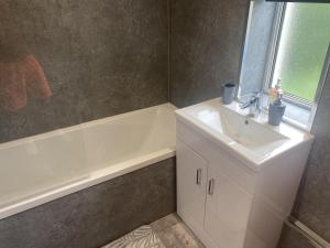 a bathroom with a sink and a bath tub at Clavens House in Glasgow