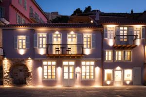 a large white building with a balcony at night at Navria by Aetoma in Nafplio