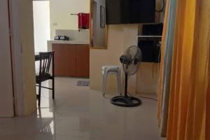 a kitchen with a floor fan and a chair at A Parallag apartment in Manila