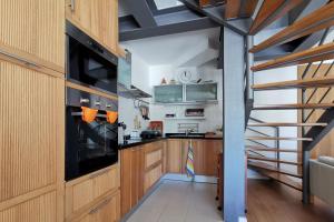 una cocina con armarios de madera y una escalera en Countryside & Beach House Ericeira - Pêra Miúda, en Ericeira