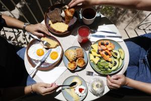 a group of people sitting at a table with breakfast foods at Pátio do Tijolo in Lisbon