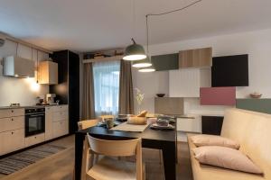 a kitchen and living room with a table and chairs at Die Alte Gerberei - La Vecchia Conceria OG1 in Monguelfo