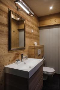 uma casa de banho com um lavatório, um WC e um espelho. em Le Coucou Hotel Restaurant & Lounge-Bar em Montreux mais 37 fotografias