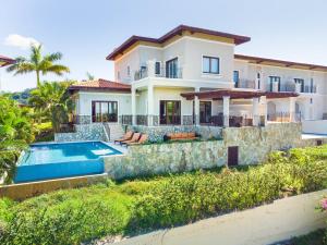 eine Villa mit Swimmingpool und ein Haus in der Unterkunft Pristine Bay 1106 home in Roatán