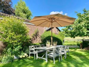 a table and chairs under an umbrella in a yard at Ferienwohnung Nina in Egestorf