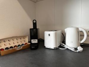 zwei Kaffeemaschinen auf einer Theke mit Kaffeeflaschen in der Unterkunft Wohnung am Marktplatz in Gießen
