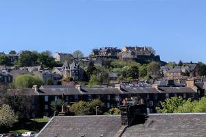 een stad met huizen en een kasteel op een heuvel bij Penthouse Apartment in Stirling