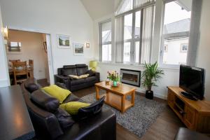 a living room with a couch and a fireplace at Penthouse Apartment in Stirling