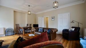 - un salon avec des canapés en cuir et une table dans l'établissement Ruchearn, à Comrie