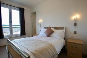 a bedroom with a large bed with a window at Penthouse Apartment in Stirling