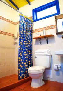 a bathroom with a toilet and a blue shower curtain at Paraíso Natural cerca Parque del Café: Altamira in Montenegro