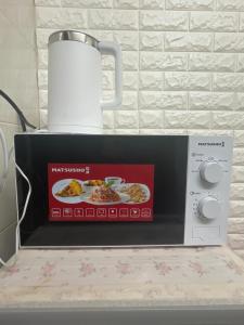 un four micro-ondes avec une photo d'une plaque de nourriture dans l'établissement Mandarin Guest House, à Hong Kong