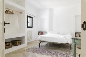 a white bedroom with a bed and a table at Trullo Vicino al Mare in Ostuni