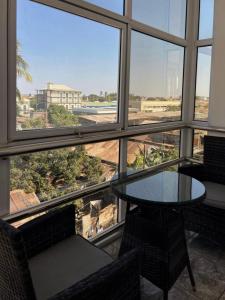a table and chairs in a room with a large window at Mahajanga Residences in Mahajanga