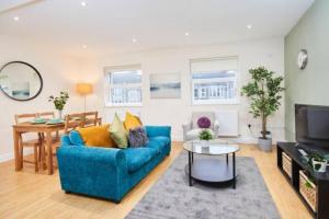 - un salon avec un canapé bleu et une table dans l'établissement Spacious Bristol Apartment - Parking & WIFI, à Bristol
