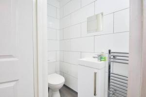 a white bathroom with a toilet and a sink at Spacious Bristol Apartment - Parking & WIFI in Bristol