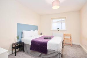ein Schlafzimmer mit einem Bett mit einer lila Decke in der Unterkunft Spacious Bristol Apartment - Parking & WIFI in Bristol
