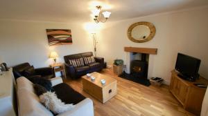 a living room with a couch and a tv at View Cottage in Lochearnhead