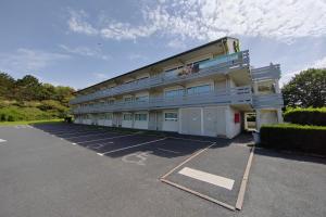 um edifício com um parque de estacionamento em frente em Campanile Caen Est - Mondeville em Mondeville