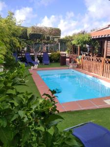 einen Pool in einem Garten mit blauen Stühlen in der Unterkunft 4 bedrooms villa with private pool enclosed garden and wifi at Bellvei 6 km away from the beach in Bellvei del Penedes