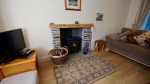 a living room with a couch and a fireplace at Waterside in Braco