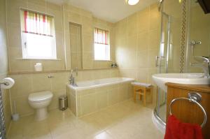 a bathroom with a tub and a toilet and a sink at Tomanour in Comrie +23 photos