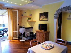 sala de estar con mesa y TV en Casa Cristina 2C - Private Free Parking, Wi-Fi, en Casarza Ligure