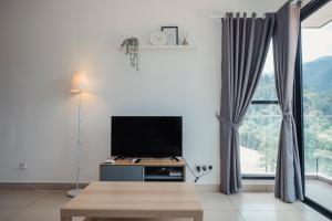a living room with a tv and a large window at Delux Suite at Midhills Genting Highlands Free WiFi in Genting Highlands