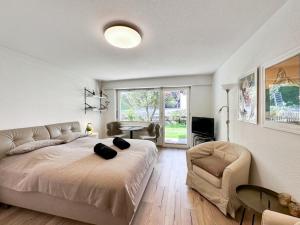 - une chambre avec un grand lit et une chaise dans l'établissement Studio Marmotta - Zermatt, à Zermatt