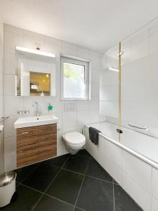 La salle de bains blanche est pourvue de toilettes et d'un lavabo. dans l'établissement Studio Marmotta - Zermatt, à Zermatt