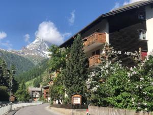 un bâtiment avec une montagne en arrière-plan dans l'établissement Studio Marmotta - Zermatt, à Zermatt