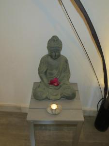 a statue of a buddha sitting on a table with a candle at BG Nautico Ebeso in Ibiza Town
