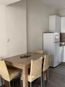 uma cozinha com uma mesa de madeira com cadeiras e um frigorífico em Apartment Marija em Ohrid