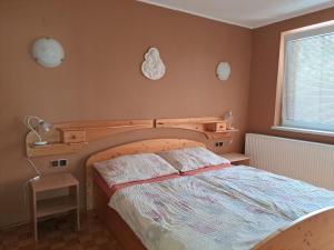 a bedroom with a bed with a wooden head board at Zdeňka in Vracov