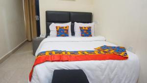 a bedroom with a large bed with a colorful blanket at RHOGEM Hotel in Sekondi-Takoradi
