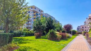 einen Garten vor einem Apartmenthaus in der Unterkunft M&R Apartament Travel&Business Premium Skoroszewska - free WiFi - self check-in - Enel-Med - FV - close the city center in Warschau