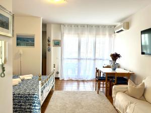 1 dormitorio con cama, mesa y ventana en Marina Bay View Apartment, en Bevazzana