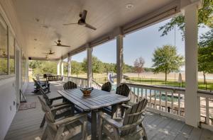 a screened porch with a wooden table and chairs at Lake Livingston Paradise Outdoor Pool with Slide! in Coldspring