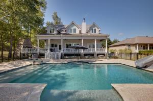 a large swimming pool in front of a house at Lake Livingston Paradise Outdoor Pool with Slide! in Coldspring