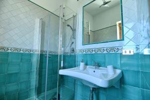un bagno con lavandino, doccia e specchio di Villa Petrinum B&B a Mondragone Altre 16 foto