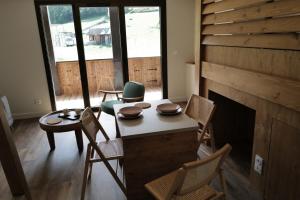 a living room with chairs and a table and a fireplace at Les Gîtes d'Aillon et d'Ailleurs in Aillon-le-Jeune