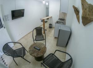 Habitación con sillas, mesa y cocina. en Hotel & Rooftop Farallones, en Betania