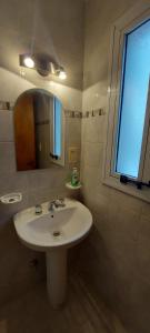 La salle de bains est pourvue d'un lavabo, d'un miroir et d'une fenêtre. dans l'établissement Edificio Correa, à Mendoza