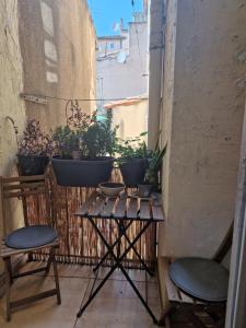 uma varanda com duas cadeiras e uma mesa com plantas em Haussmannien lumineux em Marselha