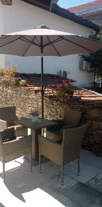 a table and chairs with an umbrella on a patio at Колеви хаус in Gabrovo