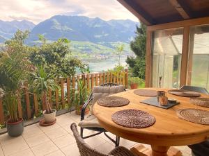 een houten tafel en stoelen op een balkon met uitzicht bij Chalet Seeblick in Sarnen