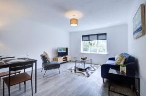 a living room with a table and chairs and a living room with a couch at Spacious 2 Bedroom Apartment in London